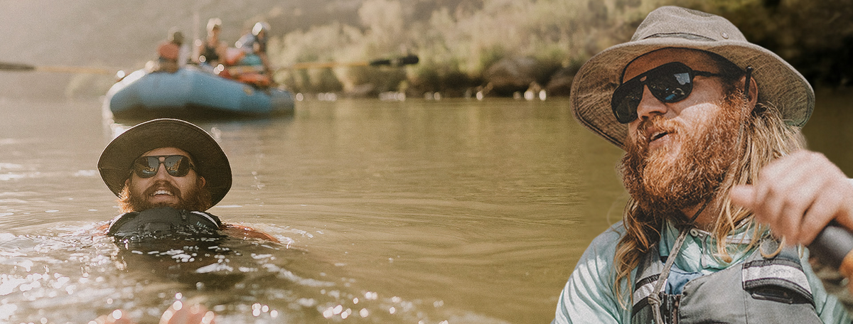 A paddler swimming alongside a raft wearing Ombraz armless sunglasses